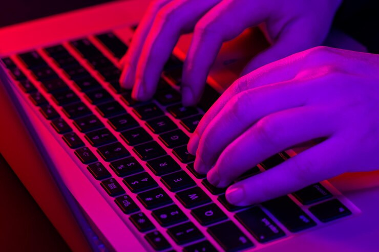 man-uses-laptop-closeup-male-hands-neon-lighting_169016-27089